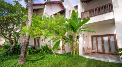A lush garden with tropical plants at the exterior of a modern resort.