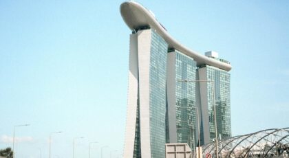 A clear daytime view of Marina Bay Sands in Singapore, showcasing its iconic architecture against a blue sky.