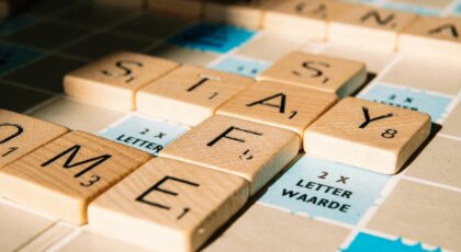 Scrabble board with tiles forming the message 'Stay Safe' in sunlight.