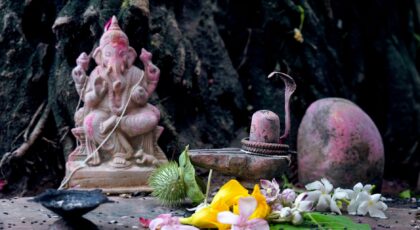 Ganesha statue with flowers and sacred objects in Ahmedabad temple, symbolizing devotion.