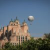 View of the iconic Atlantis Hotel with a hot air balloon in a clear sky, showcasing architectural beauty.