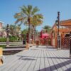 Charming wooden pier with palm trees and traditional architecture at Madinat Jumeirah, Dubai.