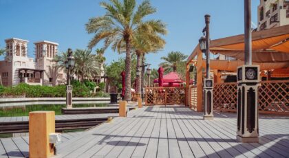 Charming wooden pier with palm trees and traditional architecture at Madinat Jumeirah, Dubai.