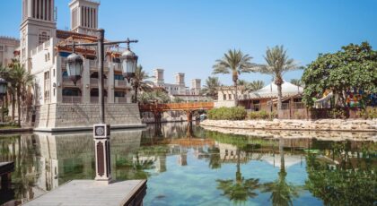 Explore the serene setting of Madinat Jumeirah Resort in Dubai, featuring traditional architecture and lush palm trees.