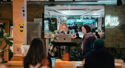 Multicultural team collaborating in a vibrant, modern office space with plants and neon light decor.