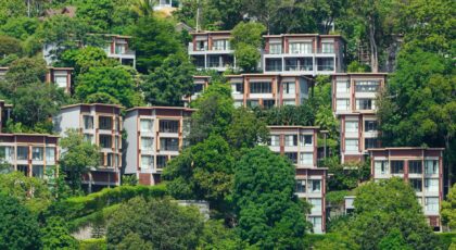 Tropical villas nestled on a lush hillside in Phuket, Thailand, showcasing vibrant greenery.