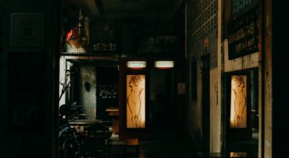 Dimly lit café interior featuring illuminated nude artwork and rustic charm.