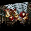 A vibrant scene of Christmas decorations in Covent Garden Market, London, with festive bells and ribbons.