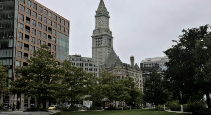 Boston's iconic Custom House Tower framed by greenery in a cityscape.