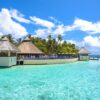 Idyllic overwater bungalows and lush greenery at a resort in Maldives, offering serene tropical paradise views.