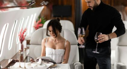 Elegant couple enjoying wine in a luxurious private jet interior.