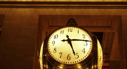 An antique clock at Grand Central Station, New York City, glowing warmly.