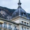 The historic Grand Hotel Victoria in Interlaken, Switzerland against a stunning alpine backdrop.