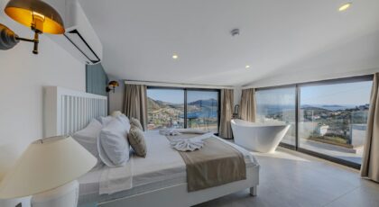 Spacious bedroom with a stunning view of the ocean, accented by contemporary design and luxury furniture.