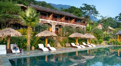 Idyllic tropical resort with a poolside view, providing leisure and relaxation, surrounded by greenery.