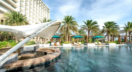 Explore this serene resort poolside, surrounded by lush palm trees and luxury amenities.