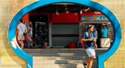 A colorful glimpse of daily life in Singapore's Chinatown with vivid architecture and bustling people.
