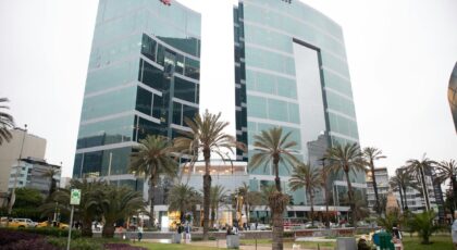 Modern architecture of JW Marriott Hotel in downtown Lima, Peru, surrounded by palm trees.