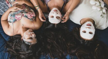 Three women applying facial masks during a relaxing spa day together.