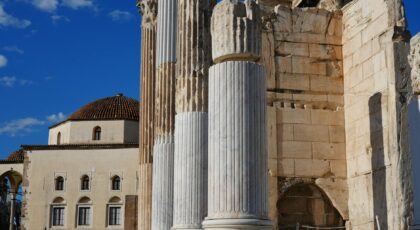 Explore the ancient architectural wonders in Athens, showcasing historical columns against a bright blue sky.
