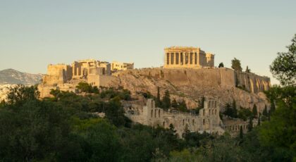 Capture of the historic Acropolis in Athens, Greece during sunset, showcasing ancient architecture and surrounding landscape.
