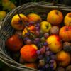 Vibrant basket of apples, grapes, and walnuts, symbolizing a rich autumn harvest.