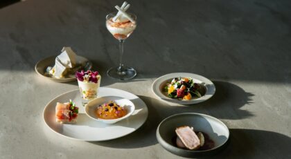 Handcrafted gourmet dishes elegantly presented under natural light on a luxurious dining table.