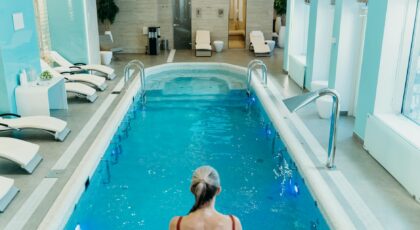 A serene indoor pool setting with a woman enjoying a relaxing swim, ideal for leisure or wellness themes.