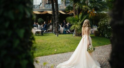 Beautiful bride in gown walking in lush garden setting during outdoor wedding in Lugano.