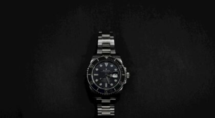 Close-up of an elegant Rolex wristwatch on a sleek black background.